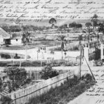 Curitiba - Fotografia em preto e branco do Passeio Público após a segunda inauguração, em 8 de agosto de 1886. O destaque é dado à entrada principal, marcada por dois pilares, localizada no Boulevar 2 de Julho (atual Avenida João Gualberto). Logo em seguida, a ponte sobre o canal do Rio Belém. À esquerda, a casa do zelador. Fotografia da Coleção Julia Wanderley. Acervo: Instituto Histórico e Geográfico do Paraná / Diretoria de Patrimônio Histórico, Artístico e Cultural / Fundação Cultural de Curitiba.