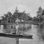 Curitiba - Postal em preto e branco que destaca um dos canais artificiais do Rio Belém. O postal mostra um canoeiro em pé em sua canoa, segurando o remo. Postal do início do século XX. Postal da Coleção Julia Wanderley. Acervo: Instituto Histórico e Geográfico do Paraná / Diretoria de Patrimônio Histórico, Artístico e Cultural / Fundação Cultural de Curitiba.